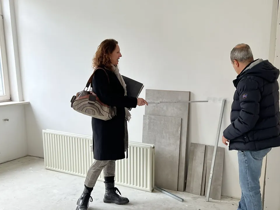 Besichtigung eines Raums im Rohbau mit einer Kundin